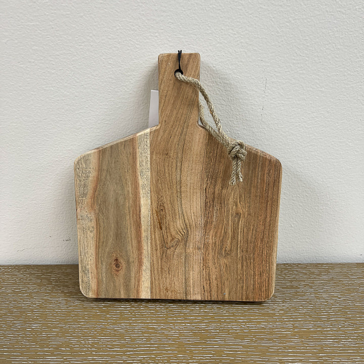 A rectangular wooden cutting board with a natural brown color, featuring a rope handle at the top.