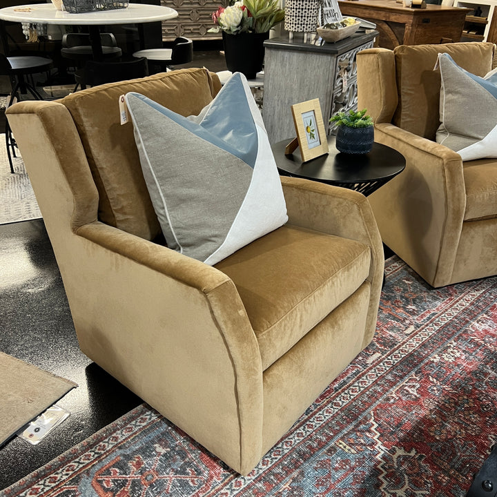 A yellow Darra swivel chair with performance fabric, featuring a classic design with armrests and a comfortable backrest, placed in a showroom setting.